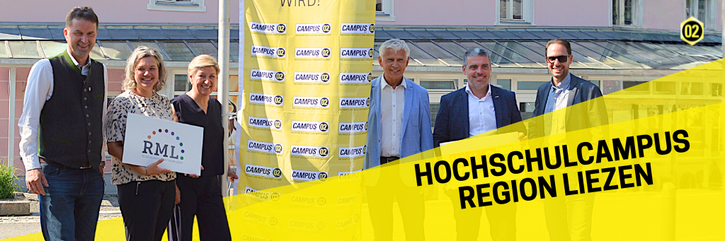 Gruppenfoto in Liezen vor einer gelben Fahne mit FH CAMPUS 02 Logo