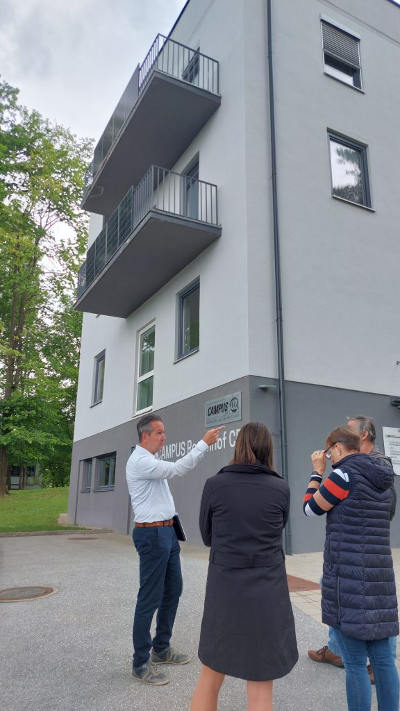 Gernot Hofer präsentiert die Balkonkraftwerke, die auf dem Bild an den Geländern der Balkone sichtbar sind.
