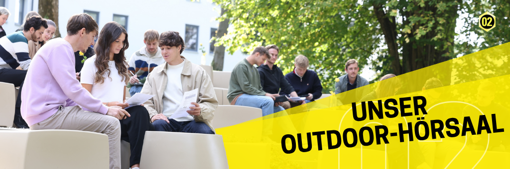 Studierende sitzen auf Bänken unter Bäumen
