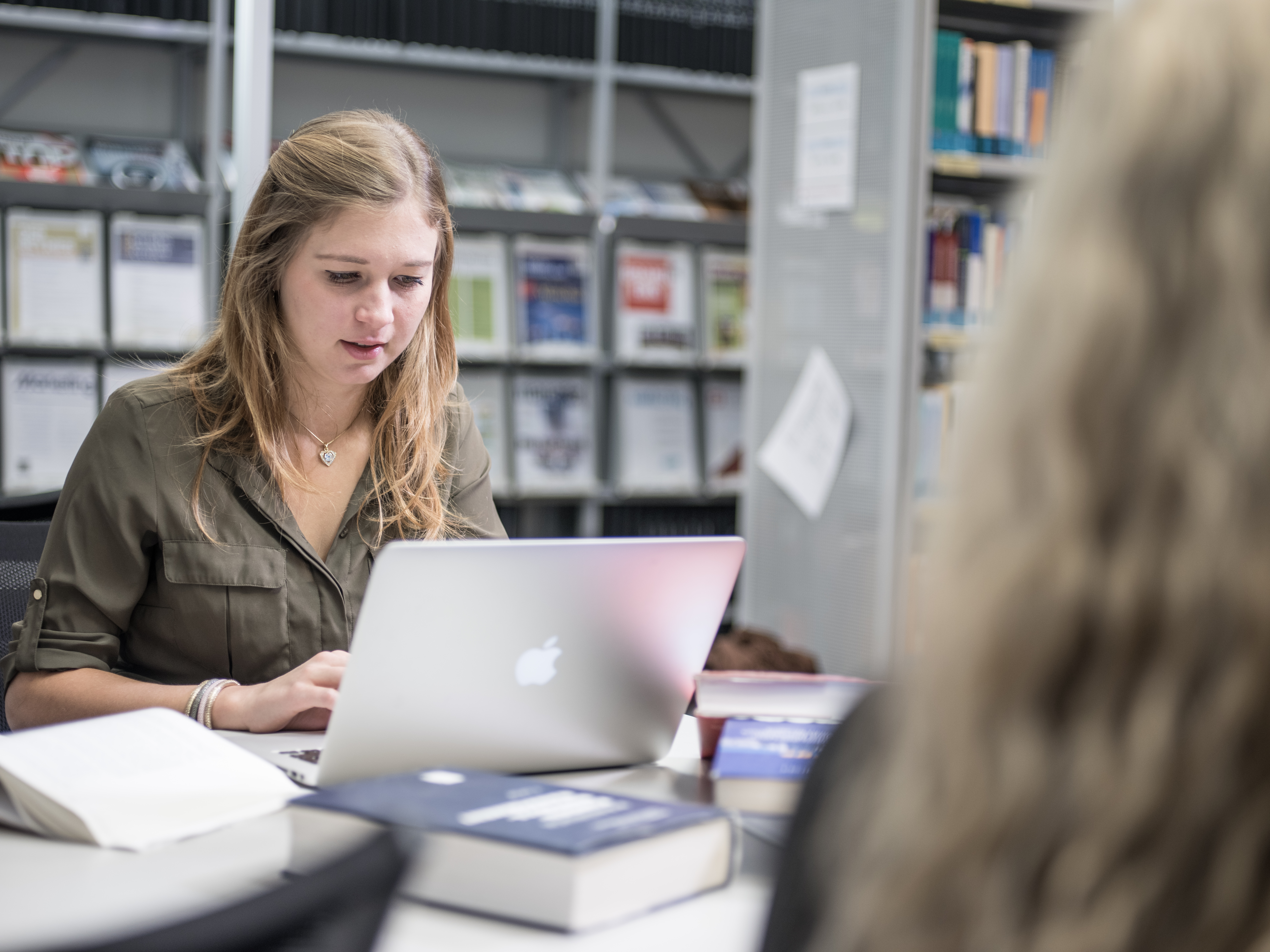 Studierende mit Laptop in der Bibliothek