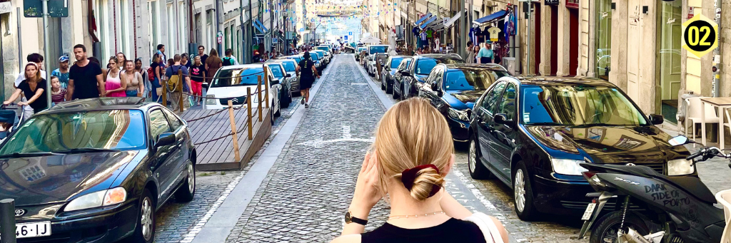 Woman standing on a street in Porto looking into the distance.