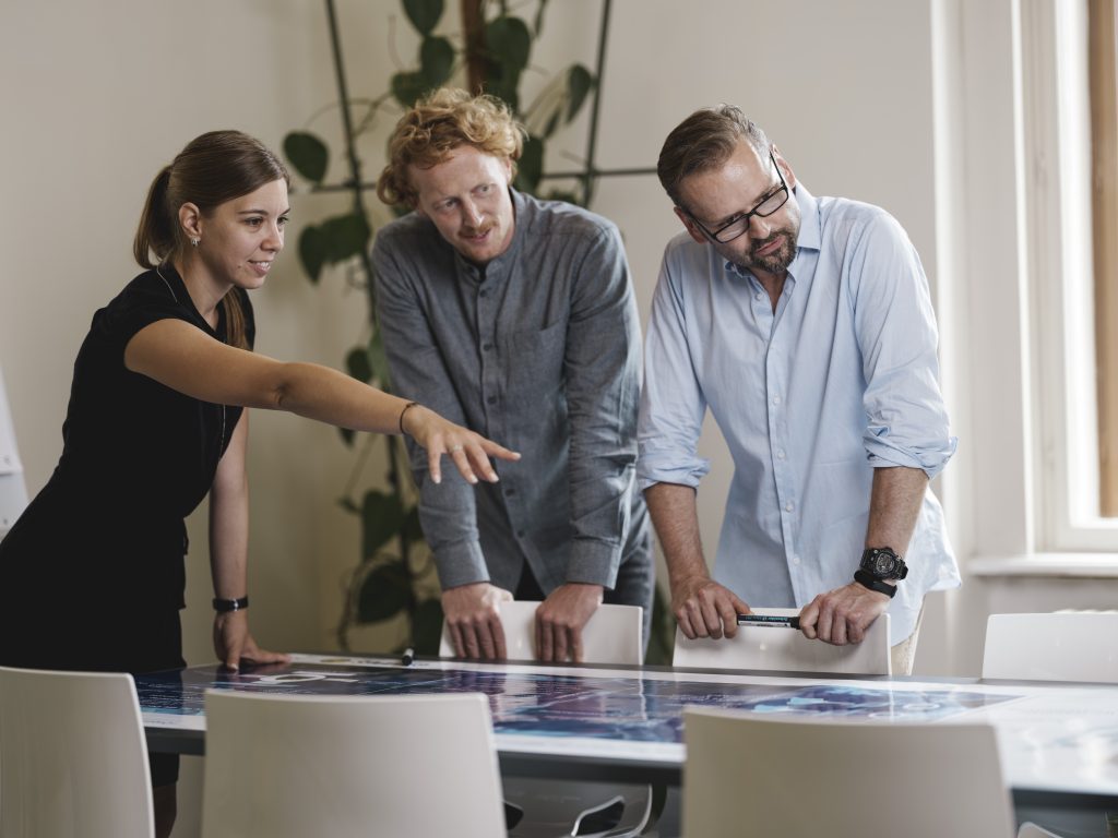 Group of people standing beside a desk working