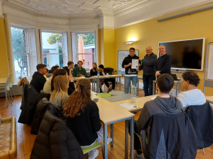 Reisegruppe sitzt gemeinsam am Tisch und ihnen wird Business Englisch gelehrt
