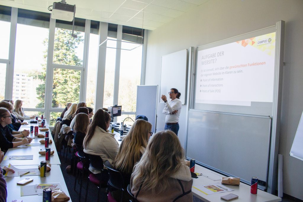 Lektor unterrichtet die HAK Unterrichtsklasse in einem Fh CAMPUS 02 Hörsaal