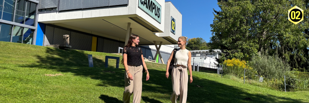 Zwei Studierende im Park vor dem Hauptgebäude der FH CAMPUS 02