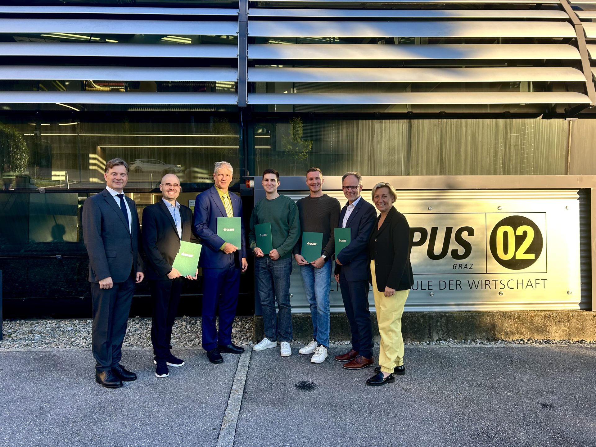 Die GRAWE Awards Gewinner mit ihren Betreuern posieren nach der Verleihung vor dem Hauptgebäude der Fachhochschule.