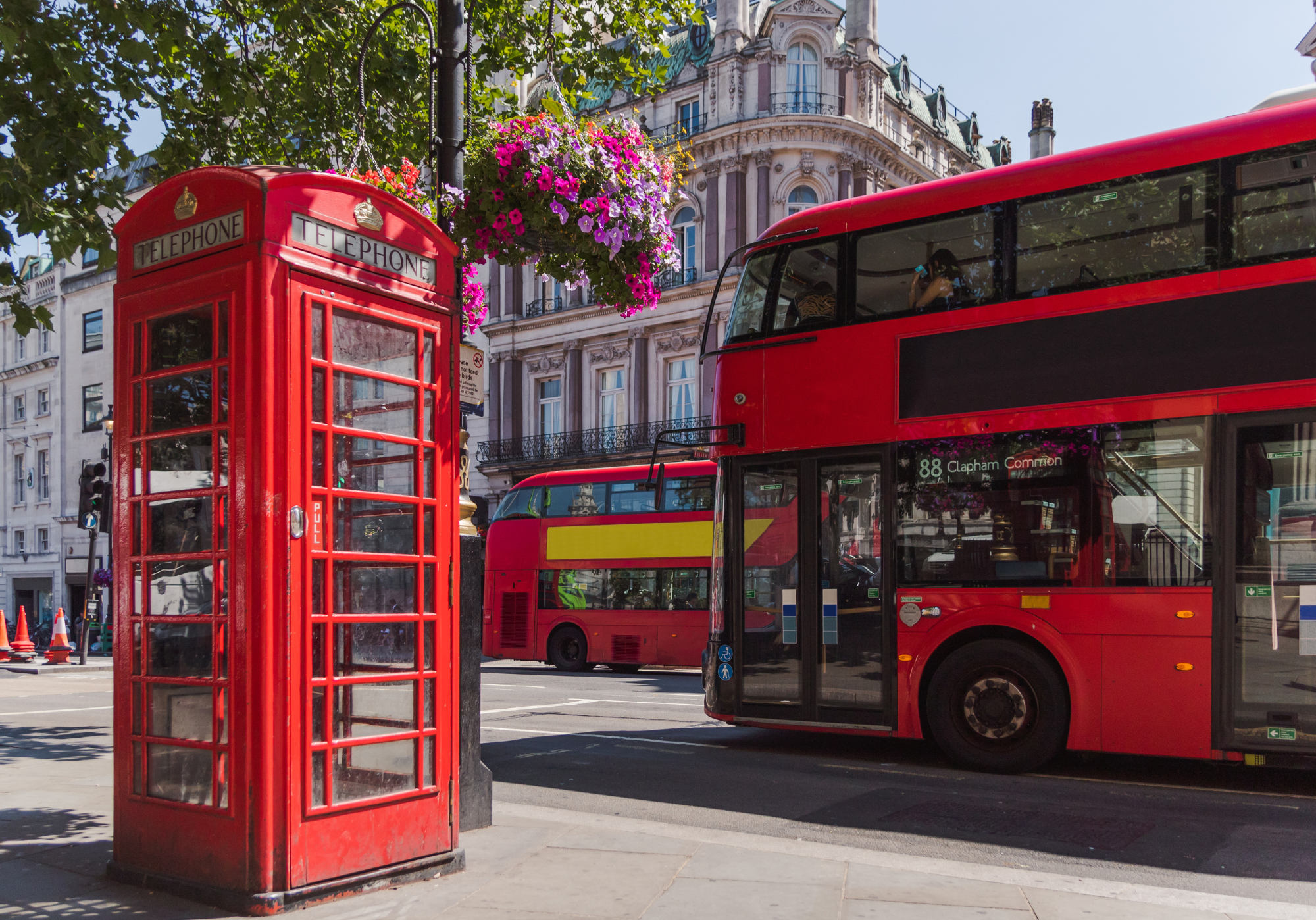 telephone booth and busses on a street in london
