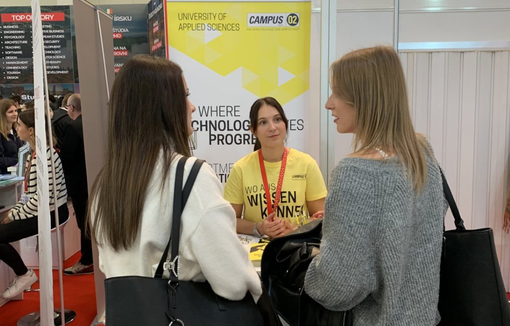 Eine Mitarbeiterin der FH CAMPUS 02 berät zwei Interessentinnen zum Studiengang Smart Automation.