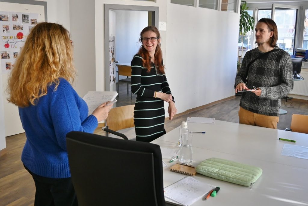 Mitarbeiterin von Ausbildungsfit präsentiert zwei Mitarbeiter*innen der FH CAMPUS 02 das Programm