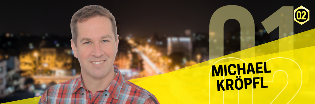 Portrait von Michael Kröpfl mit einer Straße bei Nacht im Hintergrund