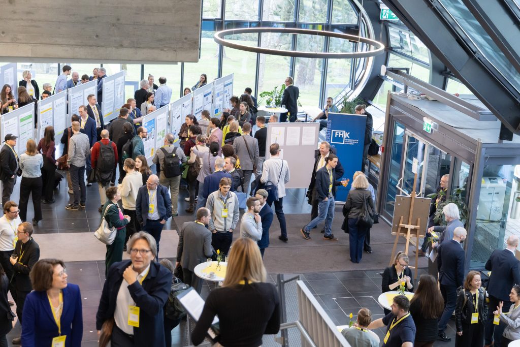 Posterausstellung in der Aula der FH CAMPUS 02 mit Besucher*innen des Forschungsforums