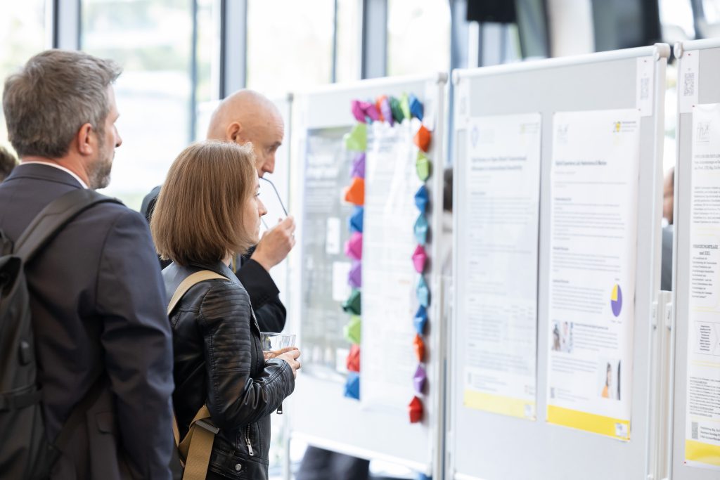 Teilnehmerin sieht sich Poster in der Posterausstellung an