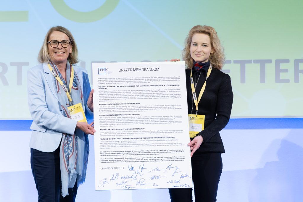 Personen halten eine Tafel mit der Aufschrift "Grazer Memorandum"