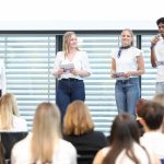 Schüler*innen reden auf der Bühne